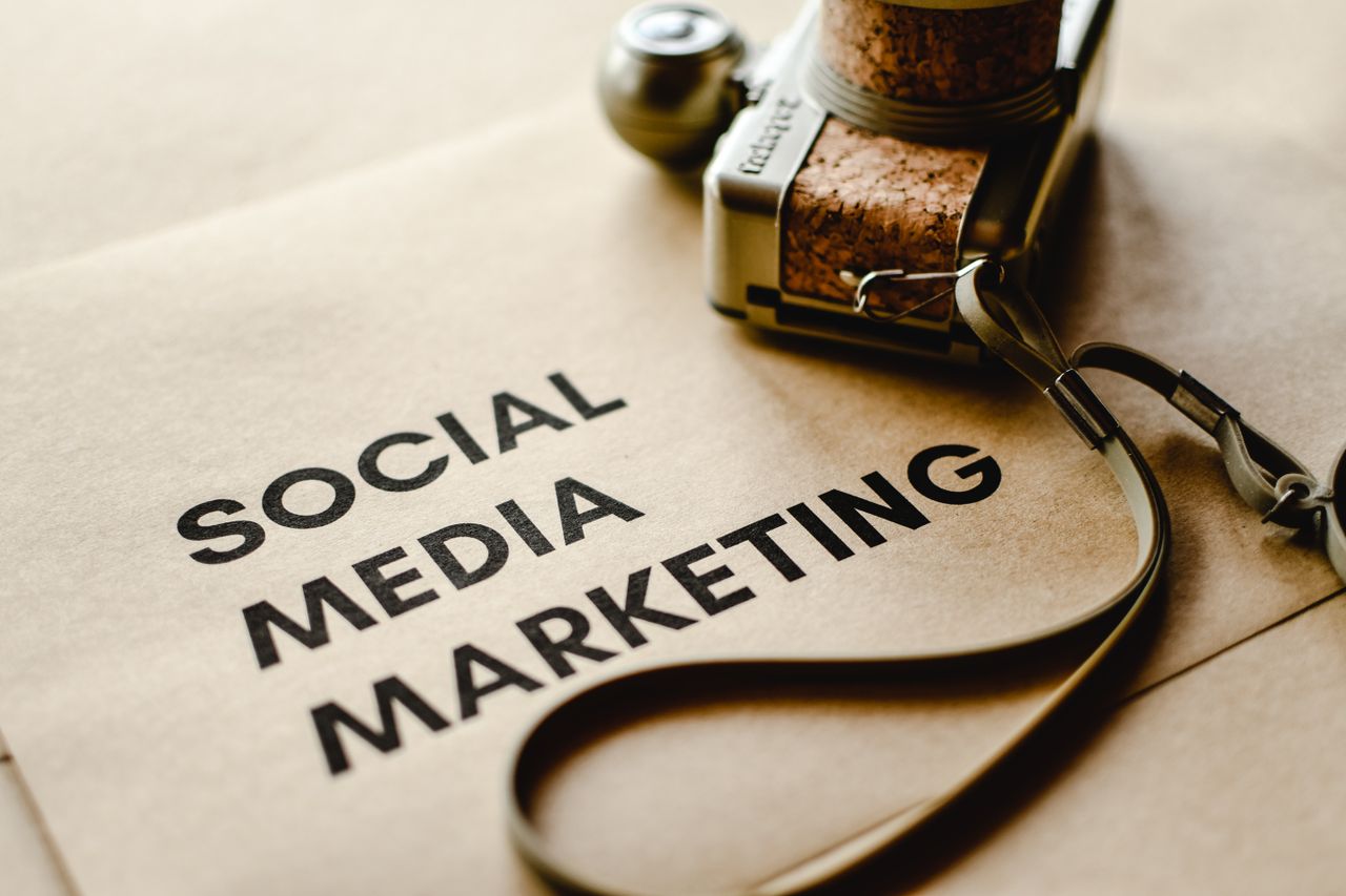 about-002 Close-up of a camera placed on brown paper with Social Media Marketing text, emphasizing digital marketing themes.